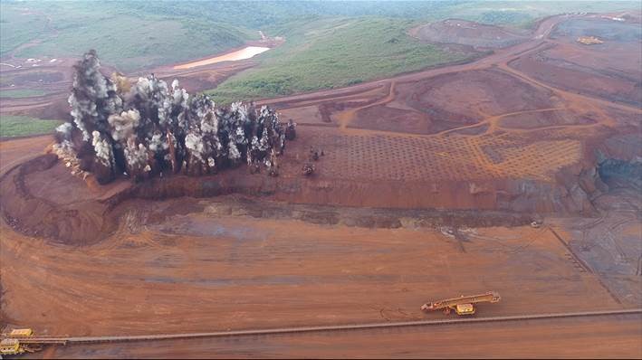 Foto aérea de uma mina aberta e um maquinário operando.
