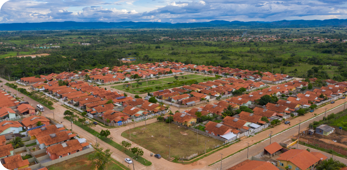 Vista aérea dos morros, vegetações e casas de uma cidade.