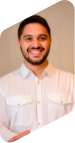 Retrato de Gabriel Salomão, homem de cabelo liso e curto e barba. Ambos na cor preta. Ele está sorrindo para a foto e usa camisa branca.