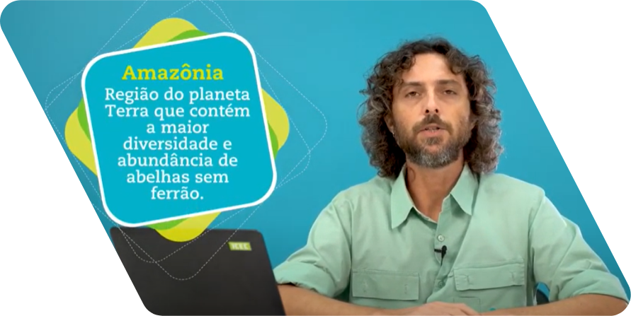 Homem branco de cabelos castanhos enrolados até a altura dos ombros e barba olhando para a câmera. Ele usa uma camisa de cor verde clara e está na frente de uma parede azul.