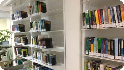 Prateleiras brancas da biblioteca ITV Desenvolvimento Sustentável com diversos livros.