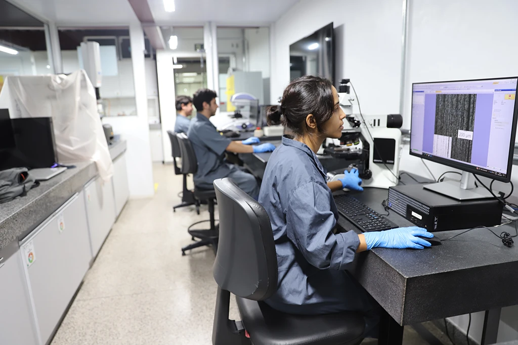 Pesquisadores no Instituto Tecnológico Vale analisando dados de amostras em um laboratório.